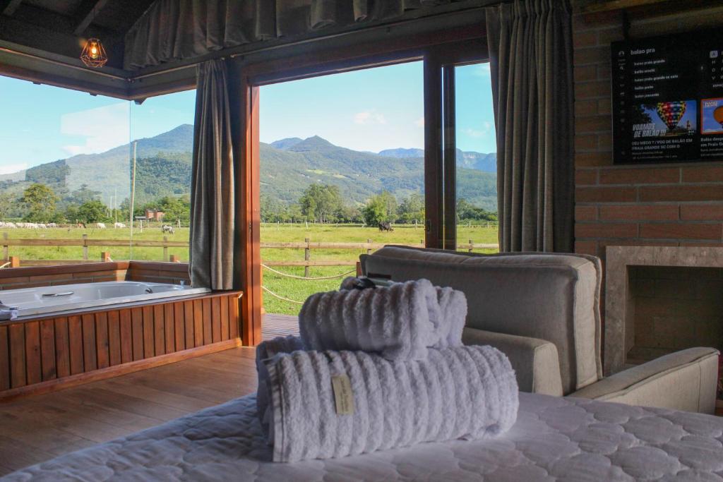 a living room with a couch and a fireplace and a window at Mirador da Montanha in Praia Grande