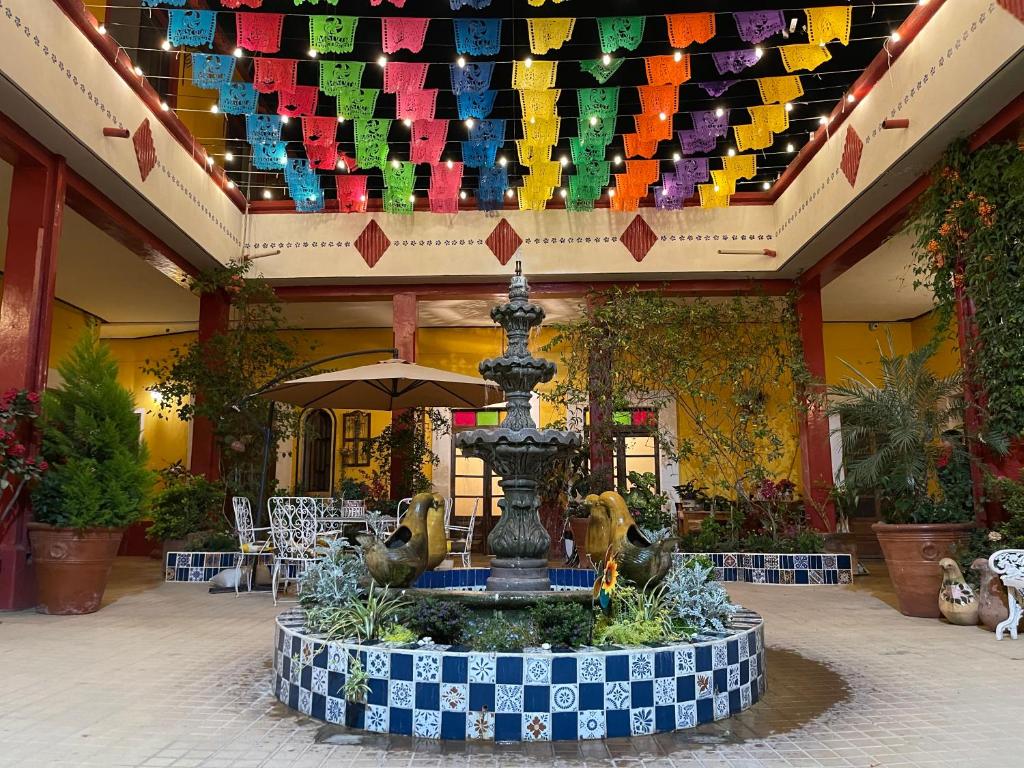einen Brunnen inmitten eines Innenhofs mit bunten Fahnen in der Unterkunft Copa de Oro Hotel Boutique in Mascota