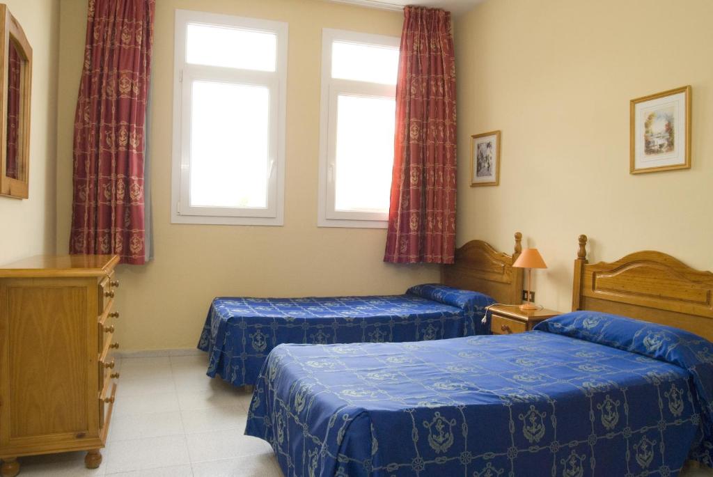 a bedroom with two beds and two windows at Apartamentos Boomerang II in Tamaduste