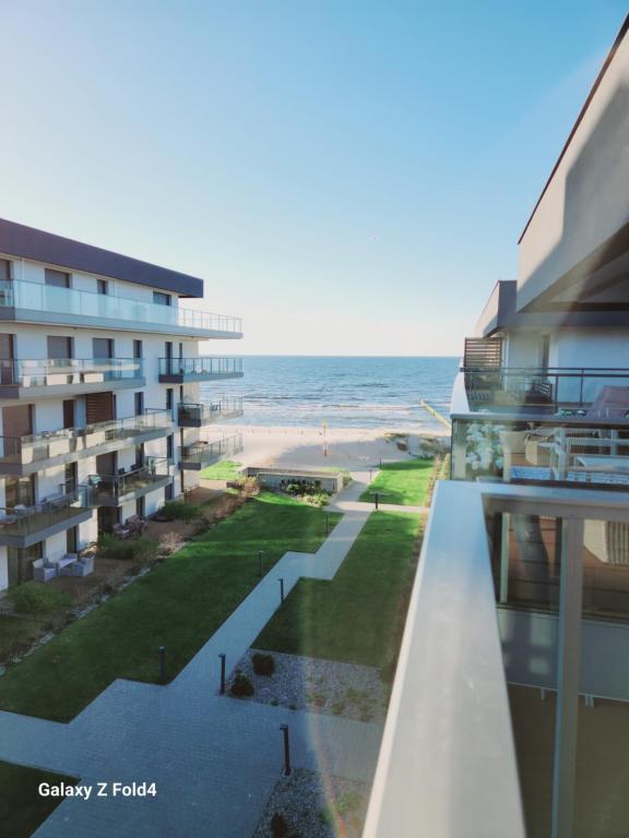 ジブヌフにあるEkskluzywny Apartament GOLD Gardenia Dziwnów z widokiem na morze trzecie piętro 1 pokojowy EPapartamentyのビーチの景色を望むバルコニーが備わる客室です。