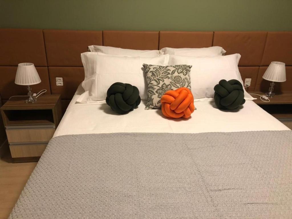 uma cama com duas abóboras e duas almofadas em Apartamento La Vista em Gramado