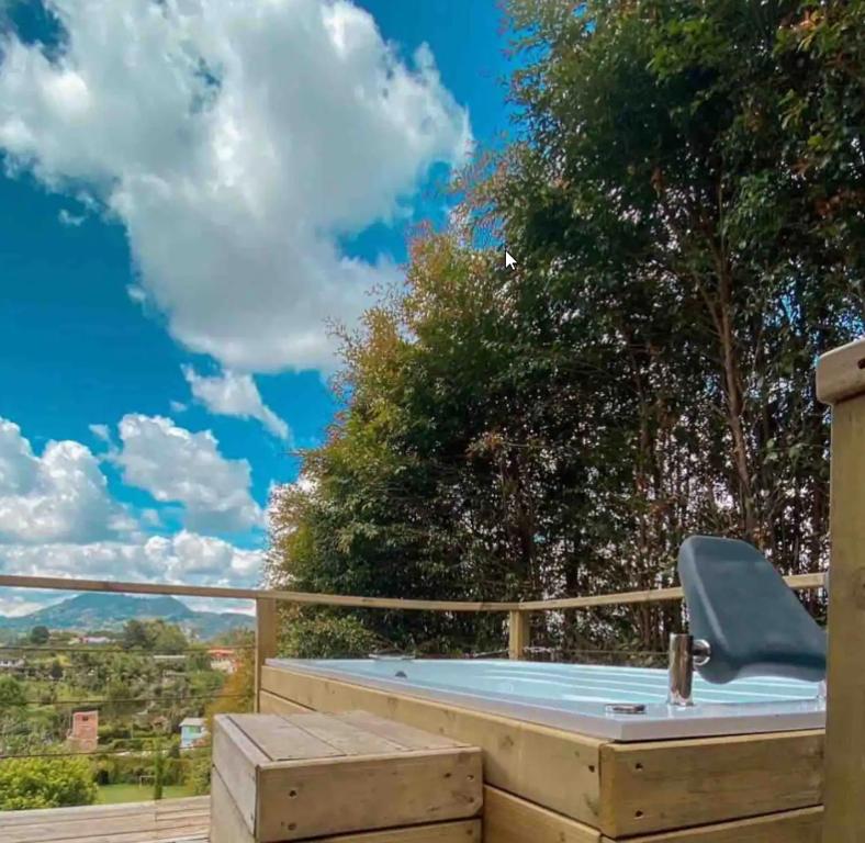 a hot tub on a deck with a blue sky at Alto Paraíso Glamping Carmen de Viboral in Rionegro