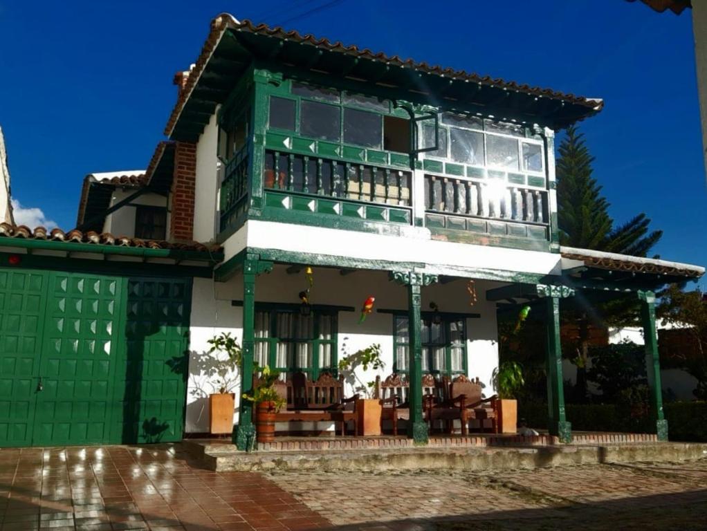 um edifício verde e branco com um pátio em Hotel Casa San Rafael em Villa de Leyva