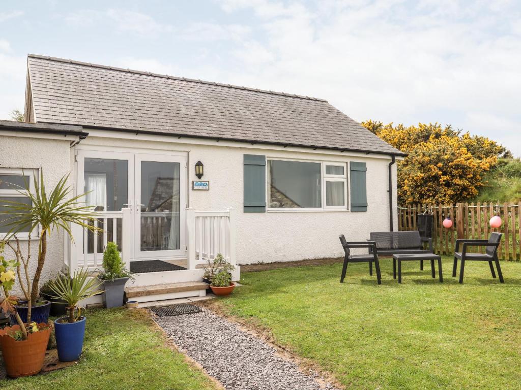 a cottage with a table and chairs in the yard at Cottage in Pwllheli