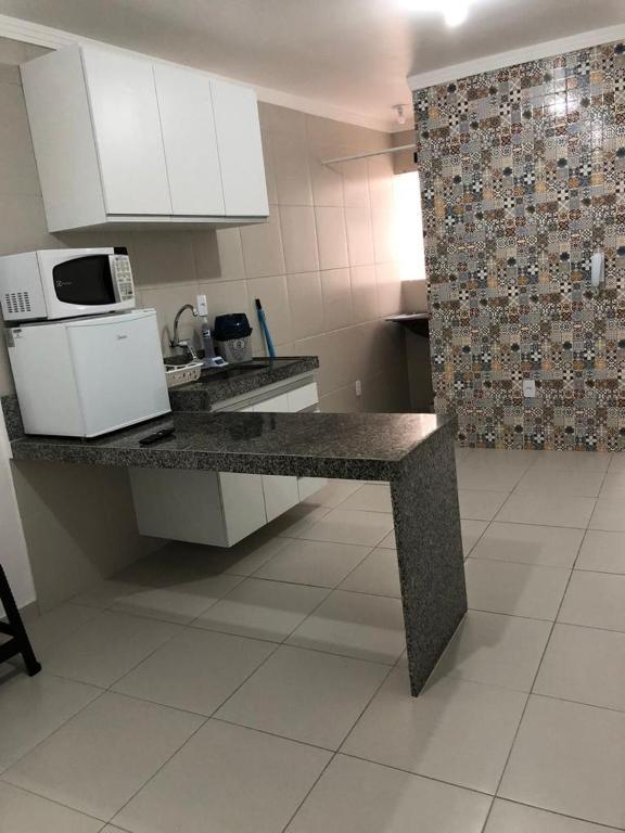 a kitchen with a counter top with a microwave at Apt05-06-07 no centro,a 800mts do pátio do forró in Caruaru