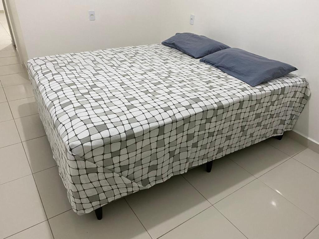 uma cama com uma almofada azul em cima em Apt05-06-07 no centro,a 800mts do pátio do forró em Caruaru