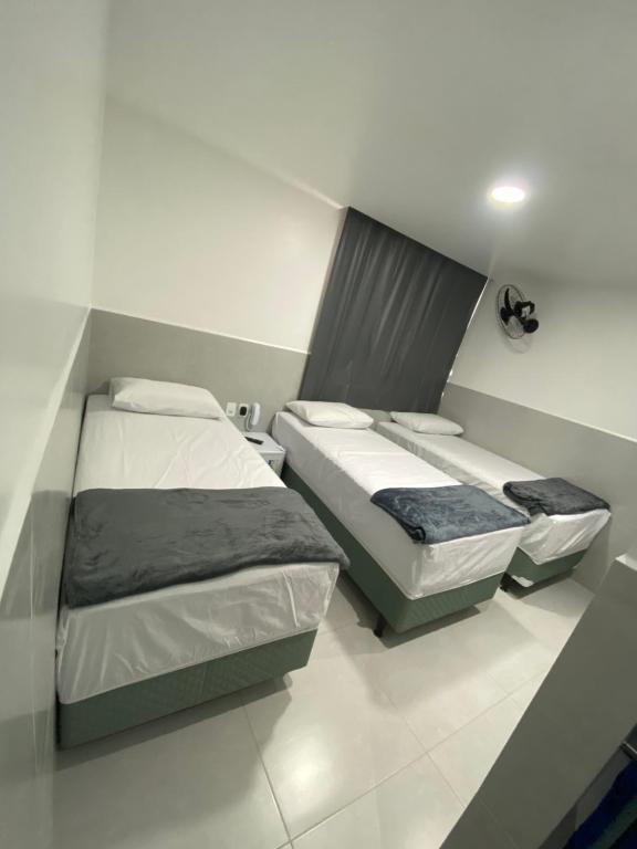 2 łóżka w małym pokoju z: w obiekcie Suíte com banheiro privativo em Pousada recém construída,a 500mts do pátio do forró w mieście Caruaru