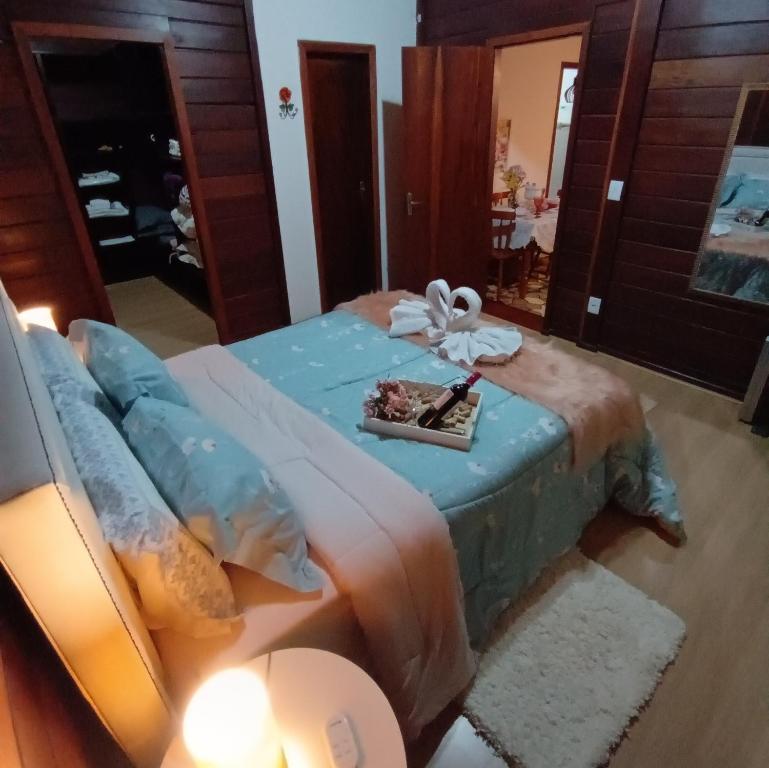 um quarto com uma cama e um espelho em Chalés Alto do Capivari em Campos do Jordão