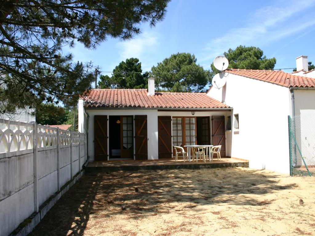 ein kleines weißes Haus mit einem Zaun und einem Tisch in der Unterkunft Maison La Tranche-sur-Mer, 2 pièces, 2 personnes - FR-1-22-218 in La Tranche-sur-Mer