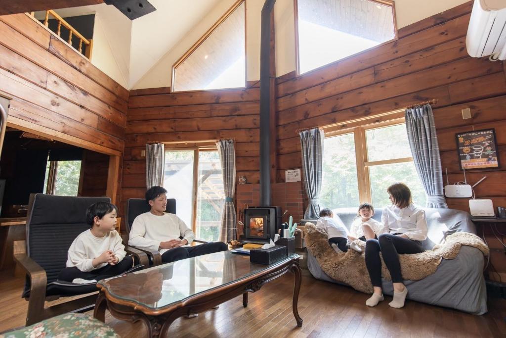 a group of people sitting in a living room at Log House Kizuki - Vacation STAY 62486v in Tsuru 