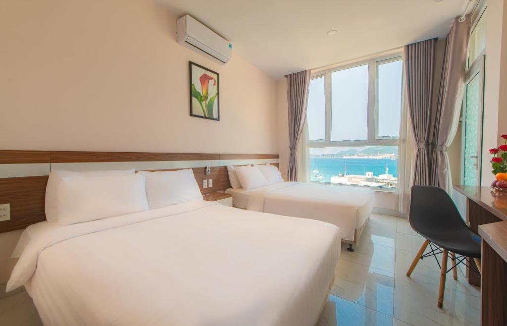 um quarto de hotel com duas camas e uma janela em CLIFF HOUSE managed by DHG em Nha Trang