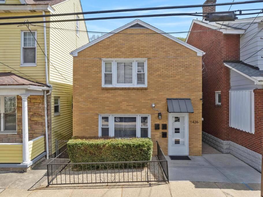 uma casa de tijolos com uma porta branca numa rua em Bright, Quiet and Modern 1Bdr Apartment in Millvale, Lawrenceville em Pittsburgh