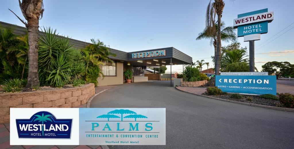 a hotel with signs in front of a building at Westland Hotel Motel in Whyalla