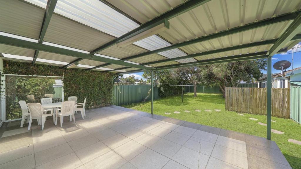 een pergola boven een patio met een tafel en stoelen bij Family Tides - Umina Beach in Ettalong Beach