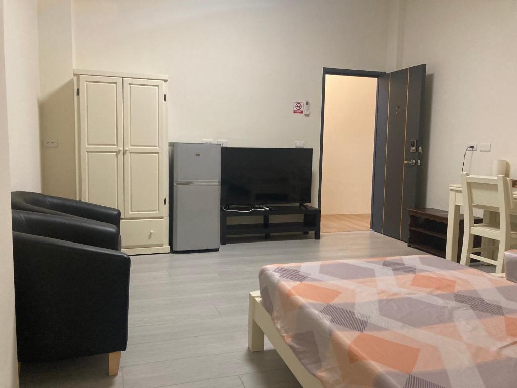 a living room with a bed and a television at 夏綠房 in Fengyuan