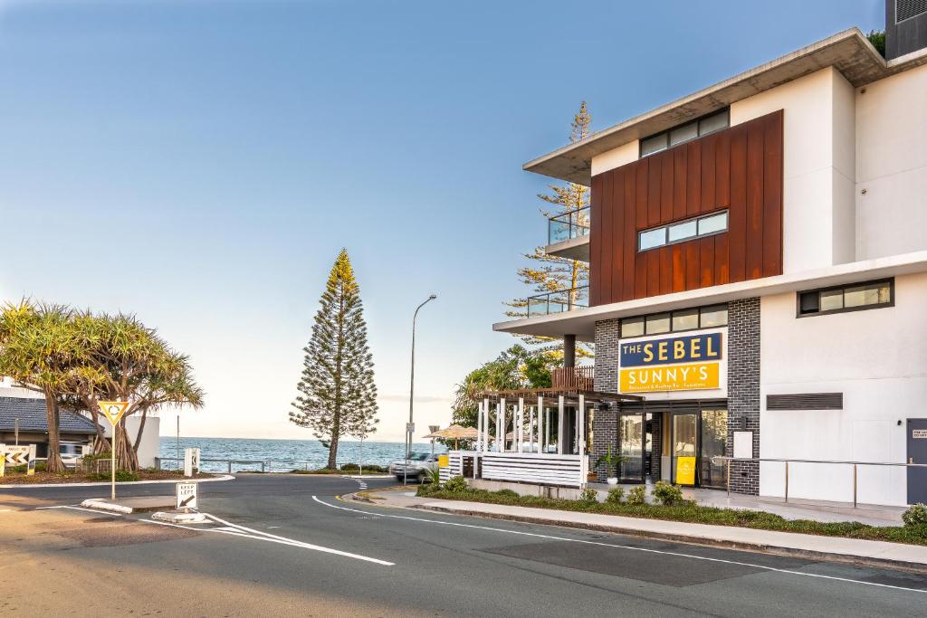 ein Gebäude auf einer Straße mit dem Ozean im Hintergrund in der Unterkunft The Sebel Brisbane Margate Beach in Redcliffe