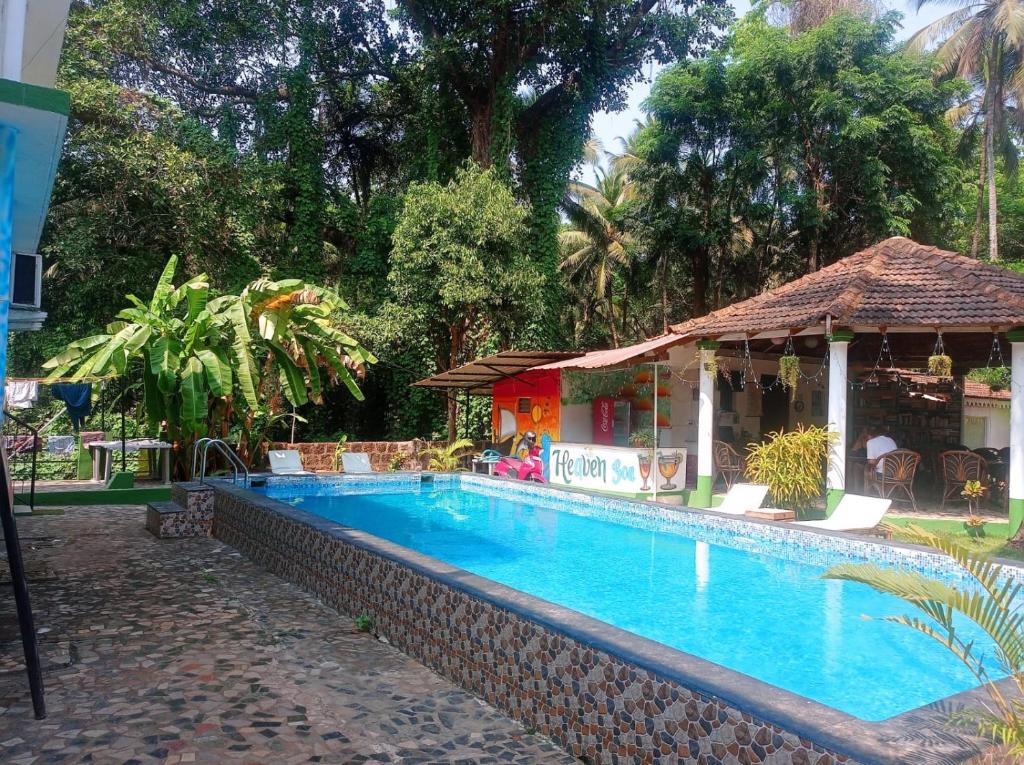 una piscina junto a un edificio con complejo en Heaven Goa Guesthouse, en Benaulim