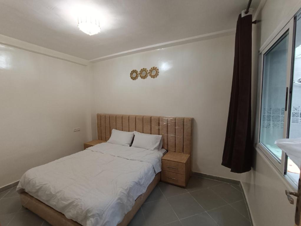 een kleine slaapkamer met een bed en een wastafel bij Mini villa dakhla in Dakhla