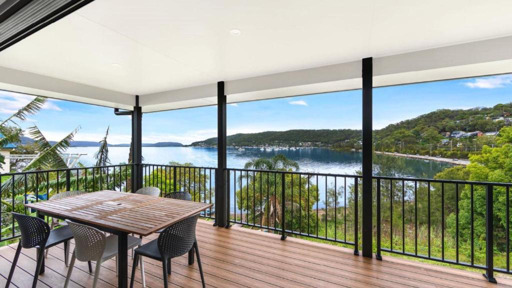 a view from the balcony of a house with a table and chairs at Bay Edge - Tascott in Point Clare