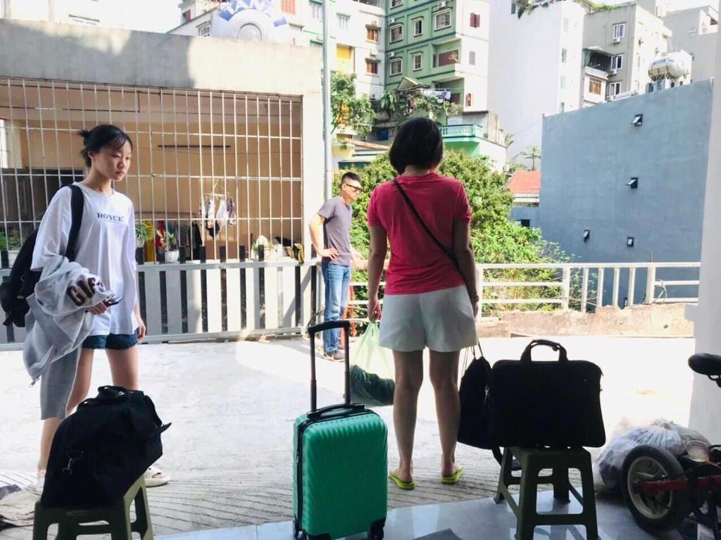a group of three women standing with their luggage at Homestay giường tầng view thoáng tại Bãi Cháy Hạ Long in Ha Long