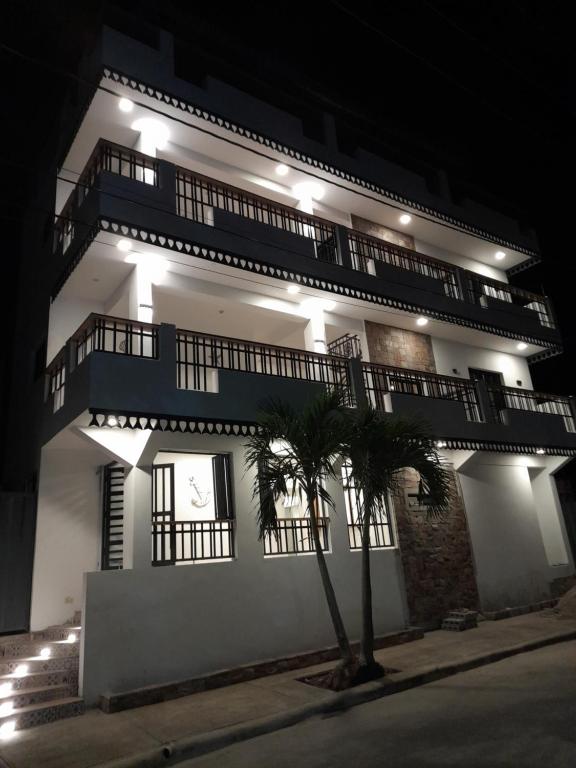 a building with a tree in front of it at night at Hostal Marina Samana in Santa Bárbara de Samaná