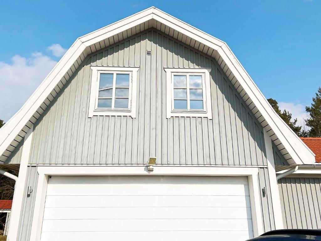 dom z drzwiami garażowymi i dwoma oknami w obiekcie Holiday home JERNA w mieście Järna