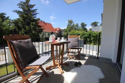 a patio with two chairs and a table on a balcony at Aquamarin Ostseetraumsuite 01 in Neuhaus