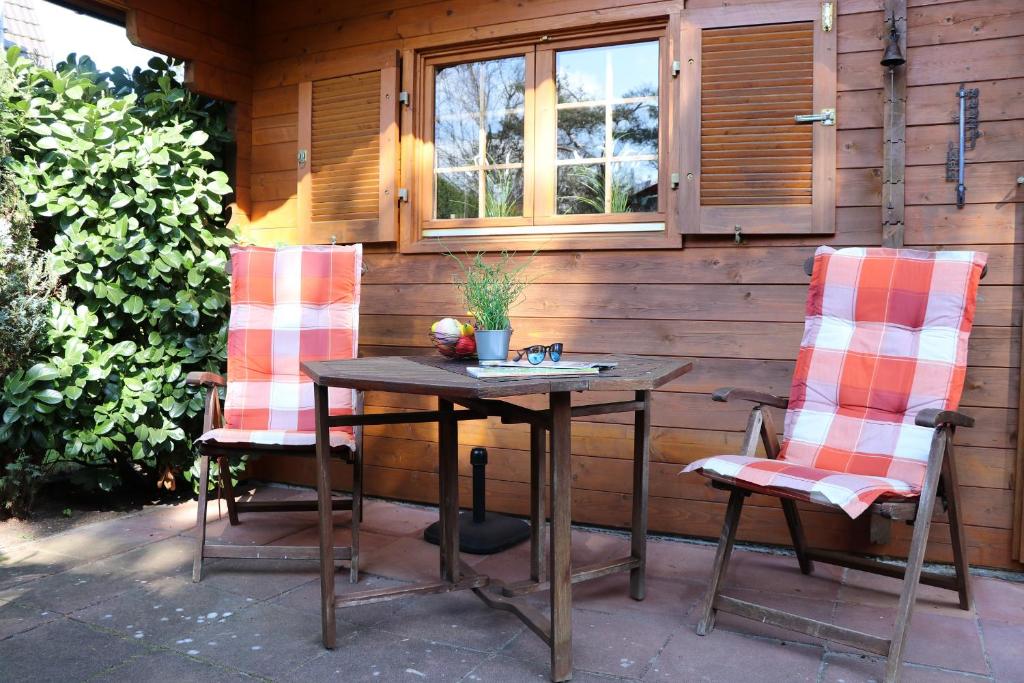 2 sillas y una mesa en el patio en Ferienhäuser Ferienhaus, Haus Auszeit en Neuhaus