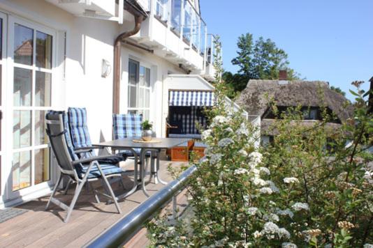 a balcony with a table and chairs on a house at Residenz am Hafen Boddensuite in Ahrenshoop