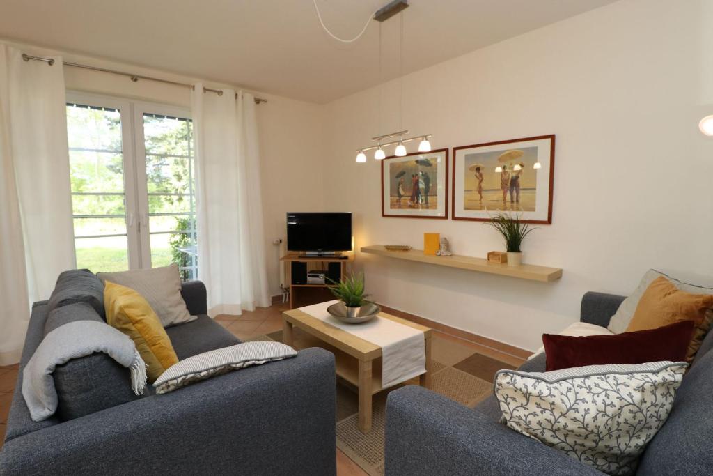 un salon avec deux canapés et une table dans l'établissement Mühlenweg, App 01, à Wieck