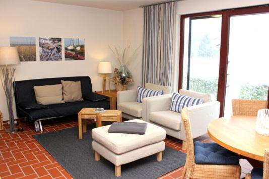 Ferienhäuser Ferienhaus Xenia في ويك: غرفة معيشة بها أريكة وطاولة