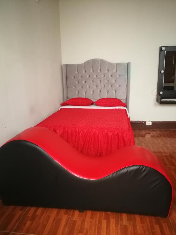 - une chambre avec un lit doté d'un couvre-lit rouge dans l'établissement una habitacion amplia para disfrutar, à Lima