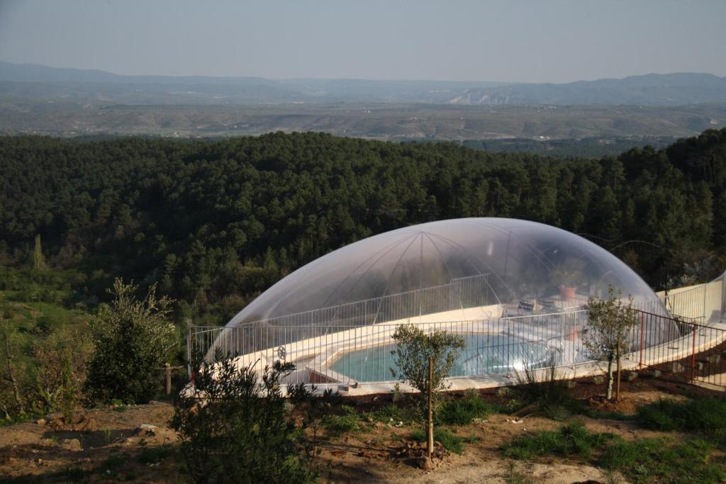 een koepelvormig gebouw met een zwembad op een heuvel bij Auberge de la Tour de Brison in Sanilhac