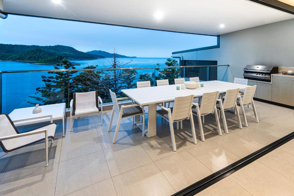 a dining room with a white table and chairs at North Cape 5 on Hamilton Island by HIHA in Hamilton Island