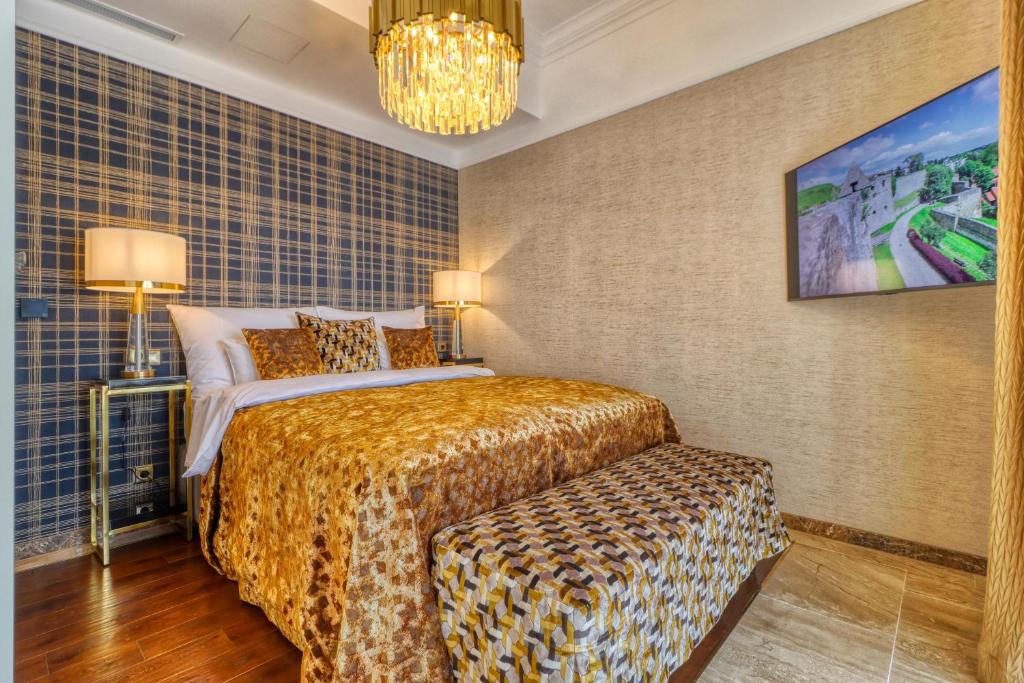 een hotelkamer met een bed en een kroonluchter bij Szeredi Residence in Eger