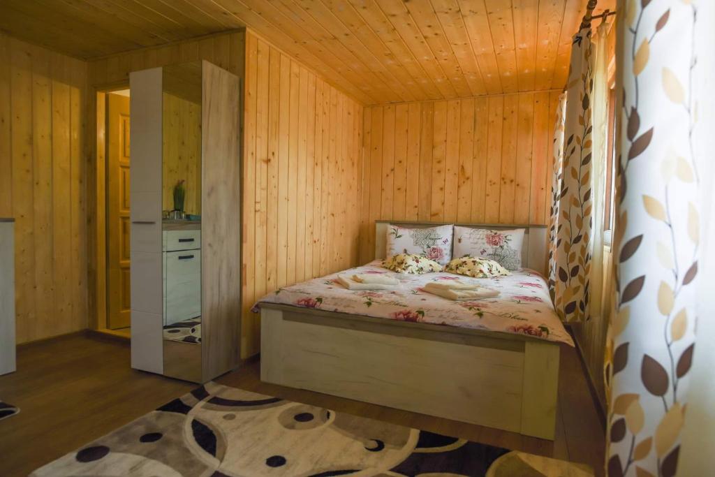 - une chambre avec un lit dans une pièce en bois dans l'établissement Cabana Anna Colibita, à Colibiţa
