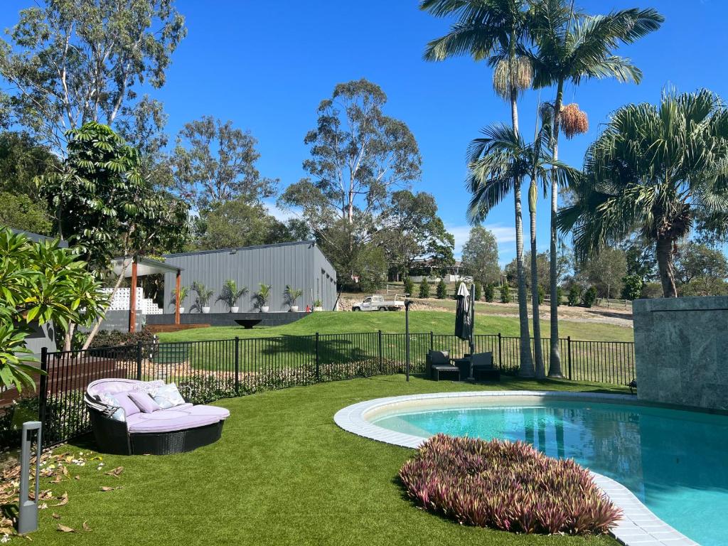 un patio trasero con piscina y césped en Gold Coast Retreat, en Ormeau