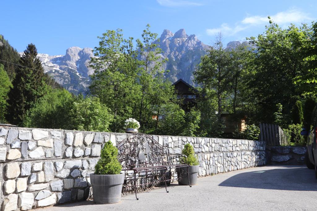 a stone fence with a bench and a stone wall with mountains at Appartement Hänsel & Gretel in Werfenweng