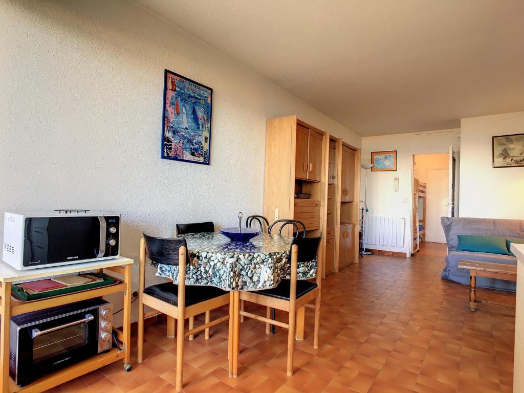 salon ze stołem z krzesłami i telewizorem w obiekcie Studio cabine sur plage avec parking et animaux admis - FR-1-715-63 w mieście Palavas-les-Flots
