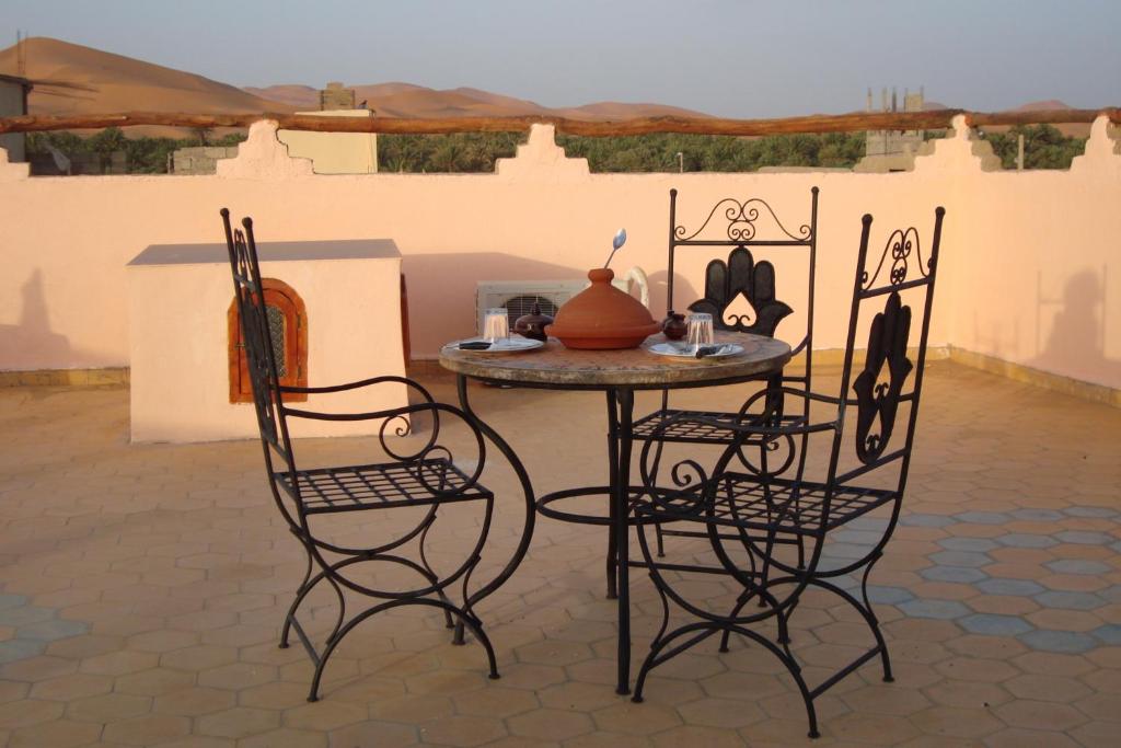 un patio con mesa y 2 sillas en Riad Aicha & Camel Trekking, en Merzouga