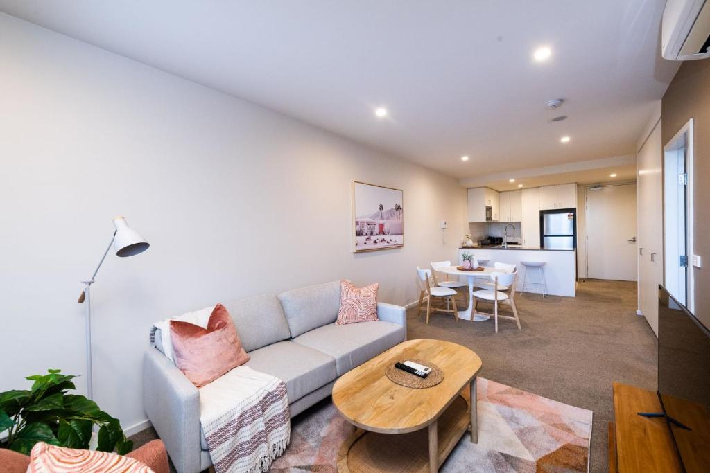 uma sala de estar com um sofá e uma mesa em Arte Apartments Braddon em Camberra