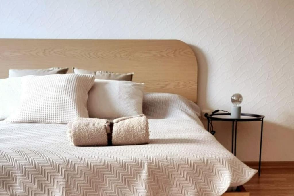 Una cama con sábanas blancas y almohadas. en Senču apartamenti No.6, en Riga