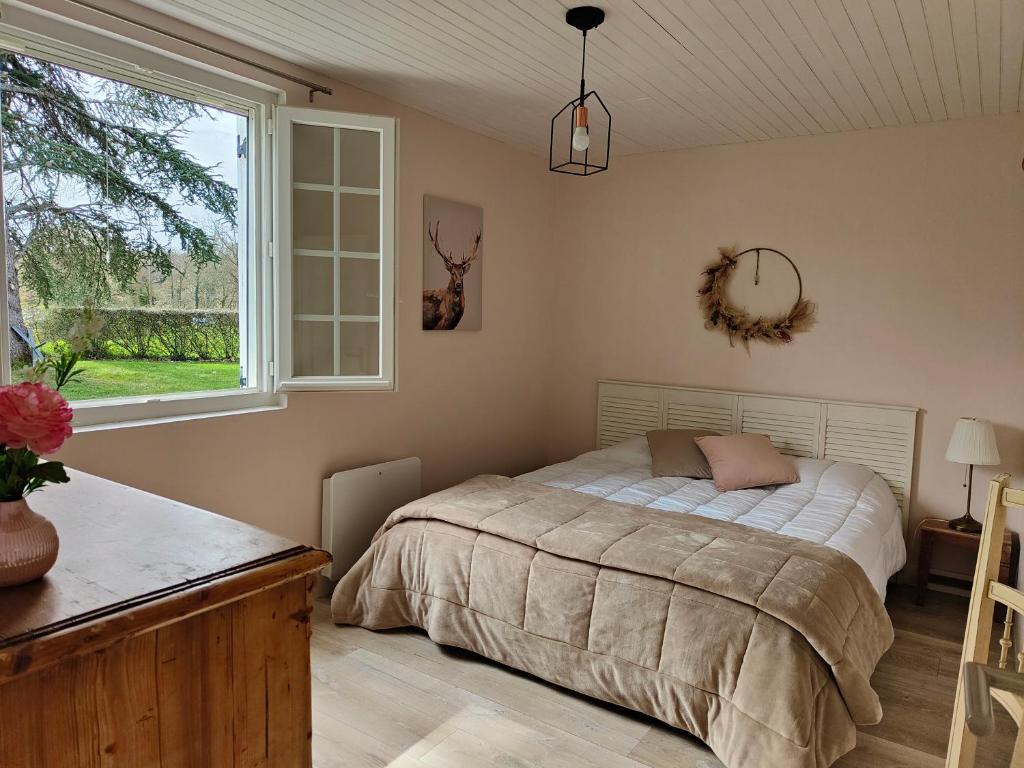een slaapkamer met een bed en een raam bij Le Gîte d'Odette in Dampierre-sous-Bouhy