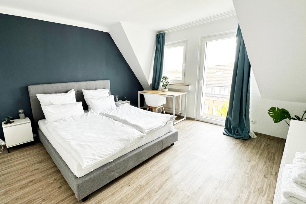 a bedroom with a large bed with a blue wall at Maisonette Apartment in Krefeld mit 2 Balkone in Krefeld