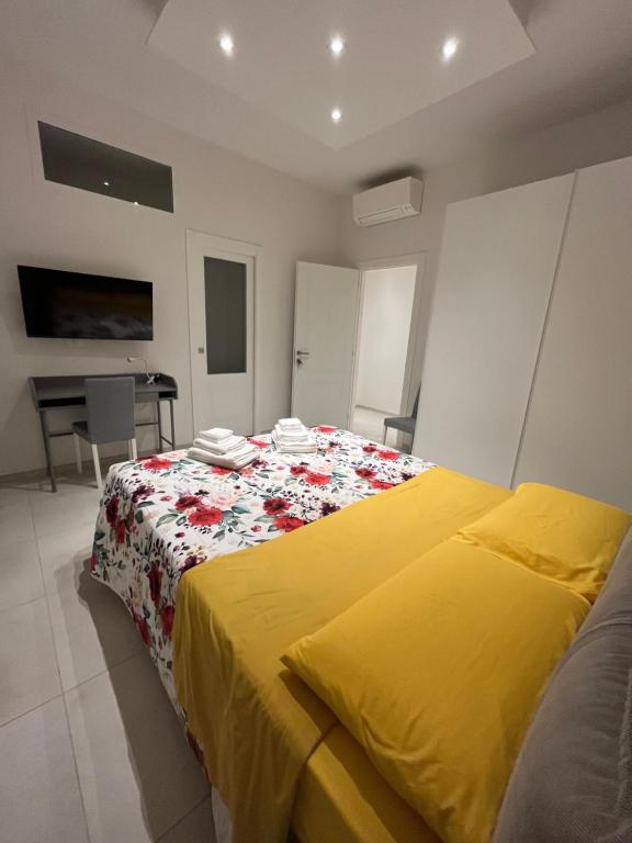 a bedroom with a bed with a yellow blanket at LUCE in Bologna