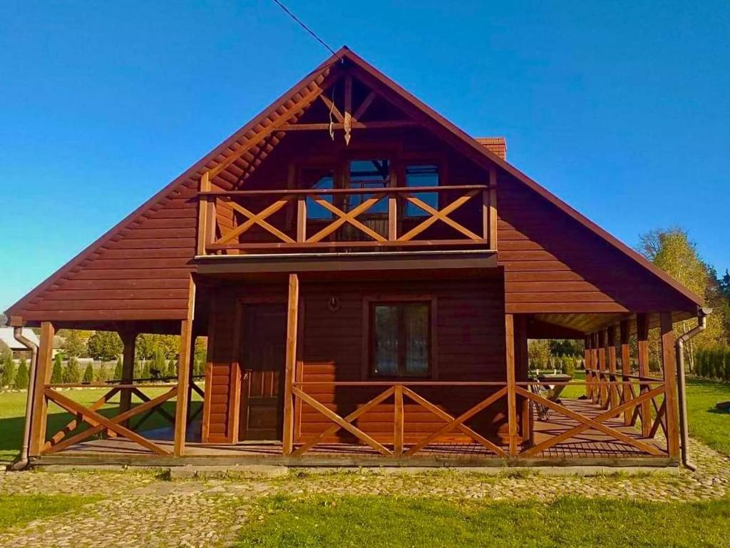 a large wooden cabin with a gambrel roof at CICHY ZAKĄTEK in Borysówka