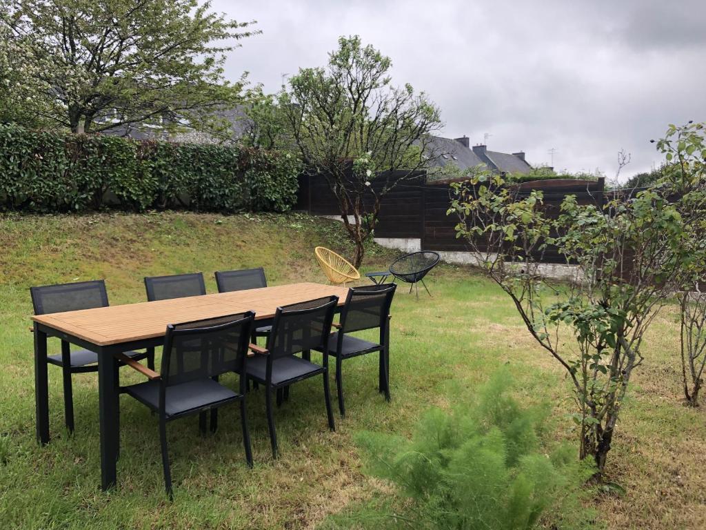 une table et des chaises en bois dans une cour dans l'établissement Maison avec jardin au calme proche centre-ville, à Vannes