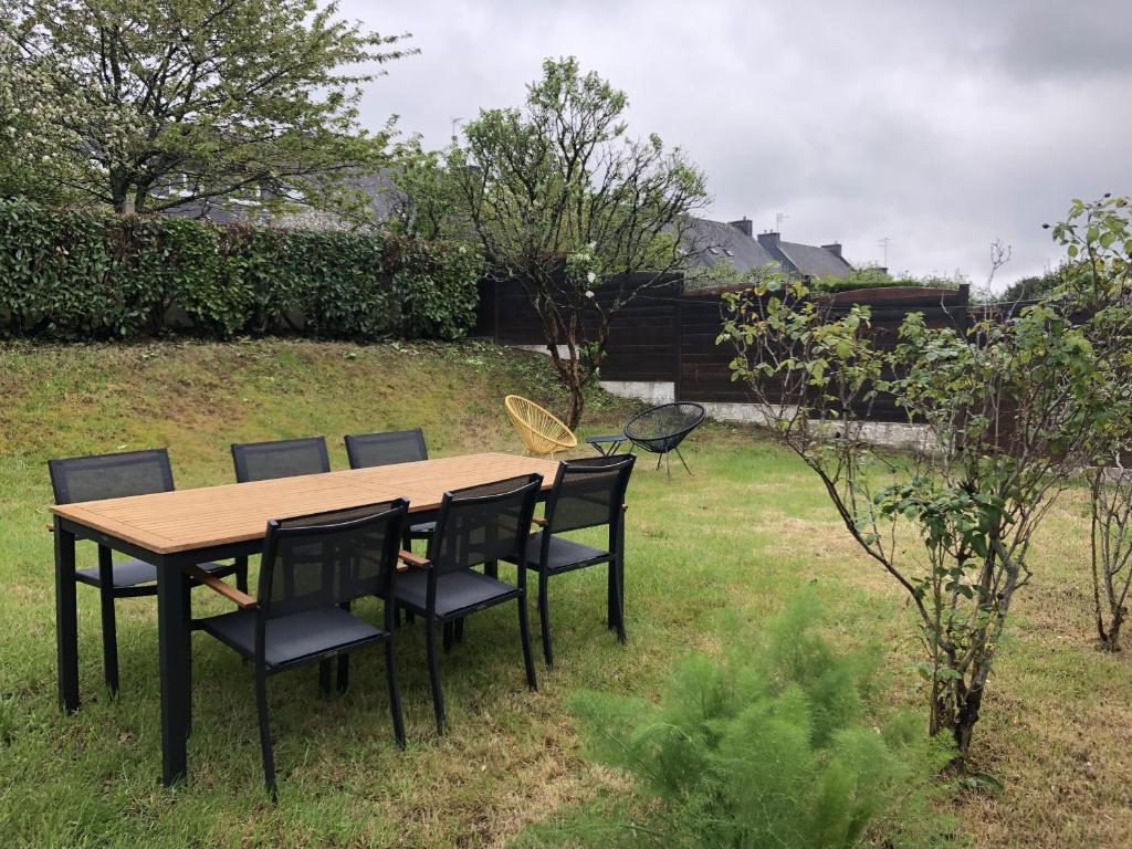 - une table et des chaises en bois dans la cour dans l'établissement Maison avec jardin au calme proche centre-ville, à Vannes