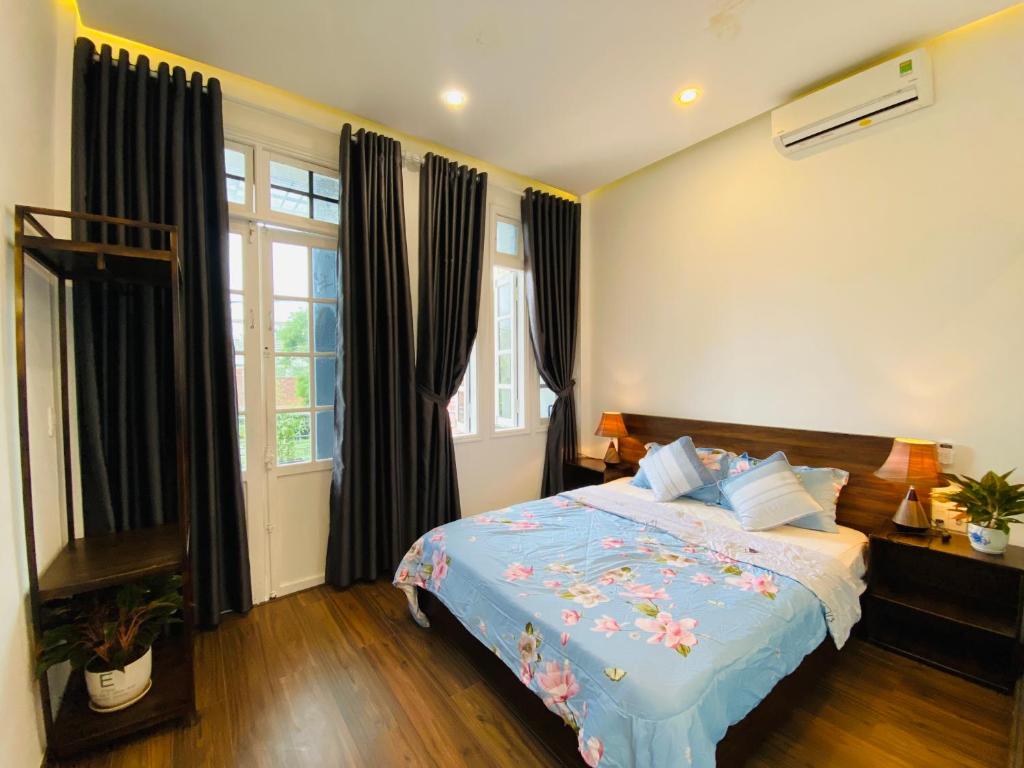 a bedroom with a bed with a blue comforter at Mia's House Hue in Thôn Kim Long (1)