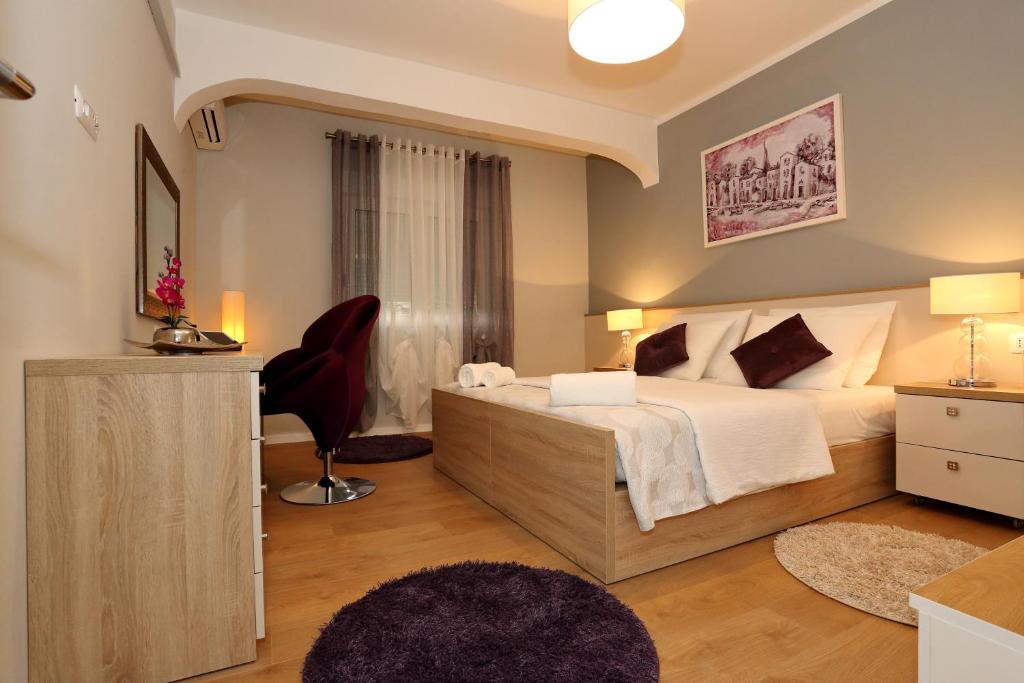 sypialnia z łóżkiem, biurkiem i krzesłem w obiekcie Luxury Maraschino Apartments w mieście Zadar
